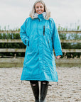 EQUIDRY Evolution Lux Women's Warm Waterproof Winter Horse Riding Coat Thick Fleece Lining with Faux Fur Trim Hood in turquoise rider in arena