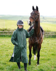 EQUIDRY waterproof horse riding raincoat thin fleece pro ride reflective black forest green rider stood with horse full front view