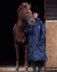 EQUIDRY women's long waterproof horse riding coat in navy/pale pink modelled by young girl with horse in stable