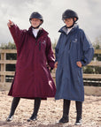 EQUIDRY Pro Ride Evolution Equestrian oversized waterproof Horse Riding Coat in Navy and plum modelled by rider's course walking a jumping arena