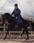 EQUIDRY Pro Ride Evolution Equestrian oversized waterproof Horse Riding Coat in Navy modelled by rider training for competition