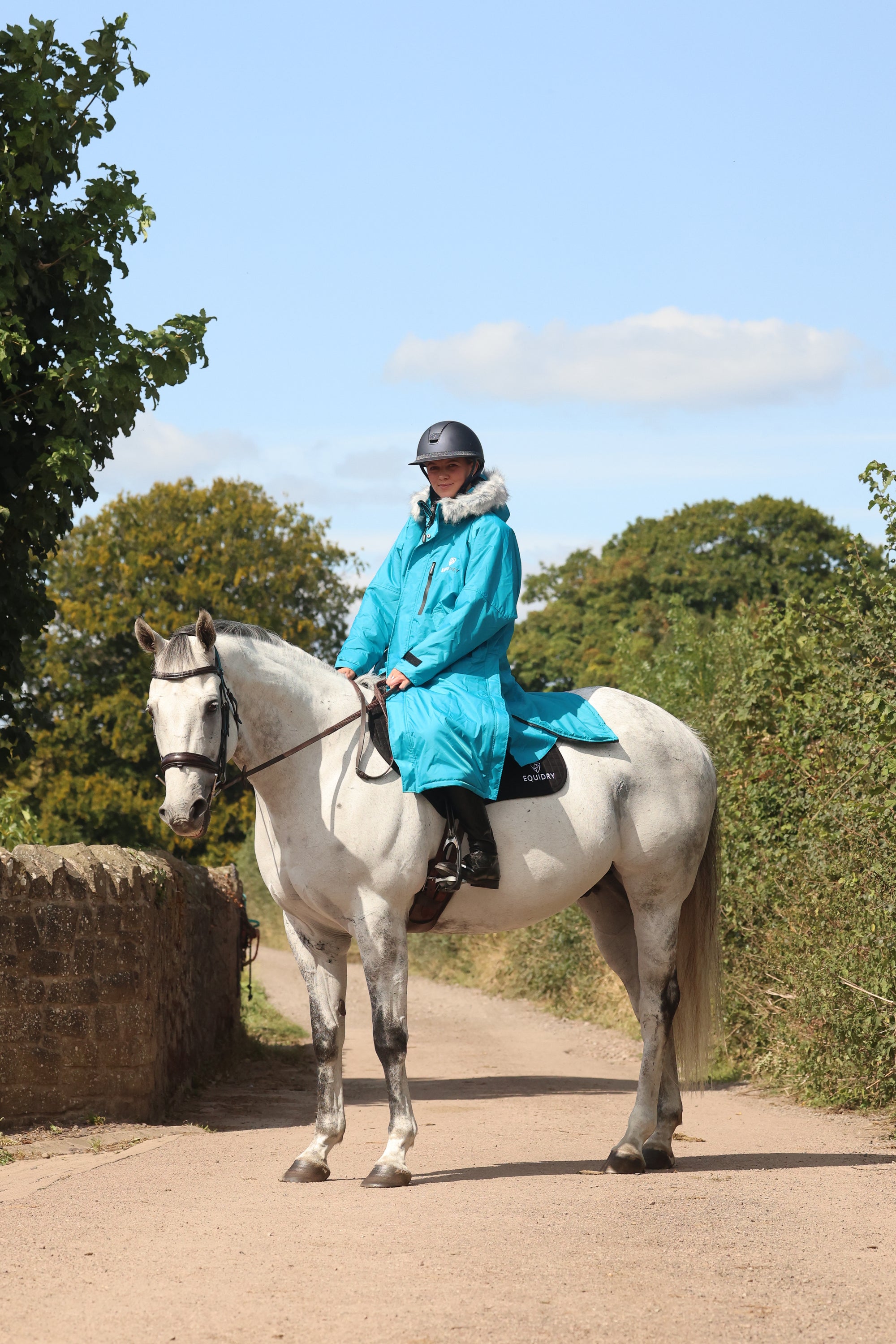 EQUIDRY Evolution Lux Women's Warm Waterproof Winter Horse Riding Coat Thick Fleece Lining with Faux Fur Trim Hood rider on horse side view 