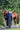 EQUIDRY women's long waterproof horse riding coat in navy/cream worn by rider walking with horse