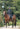 EQUIDRY women's long waterproof horse riding coat in black/turquoise modelled by rider hacking on horse