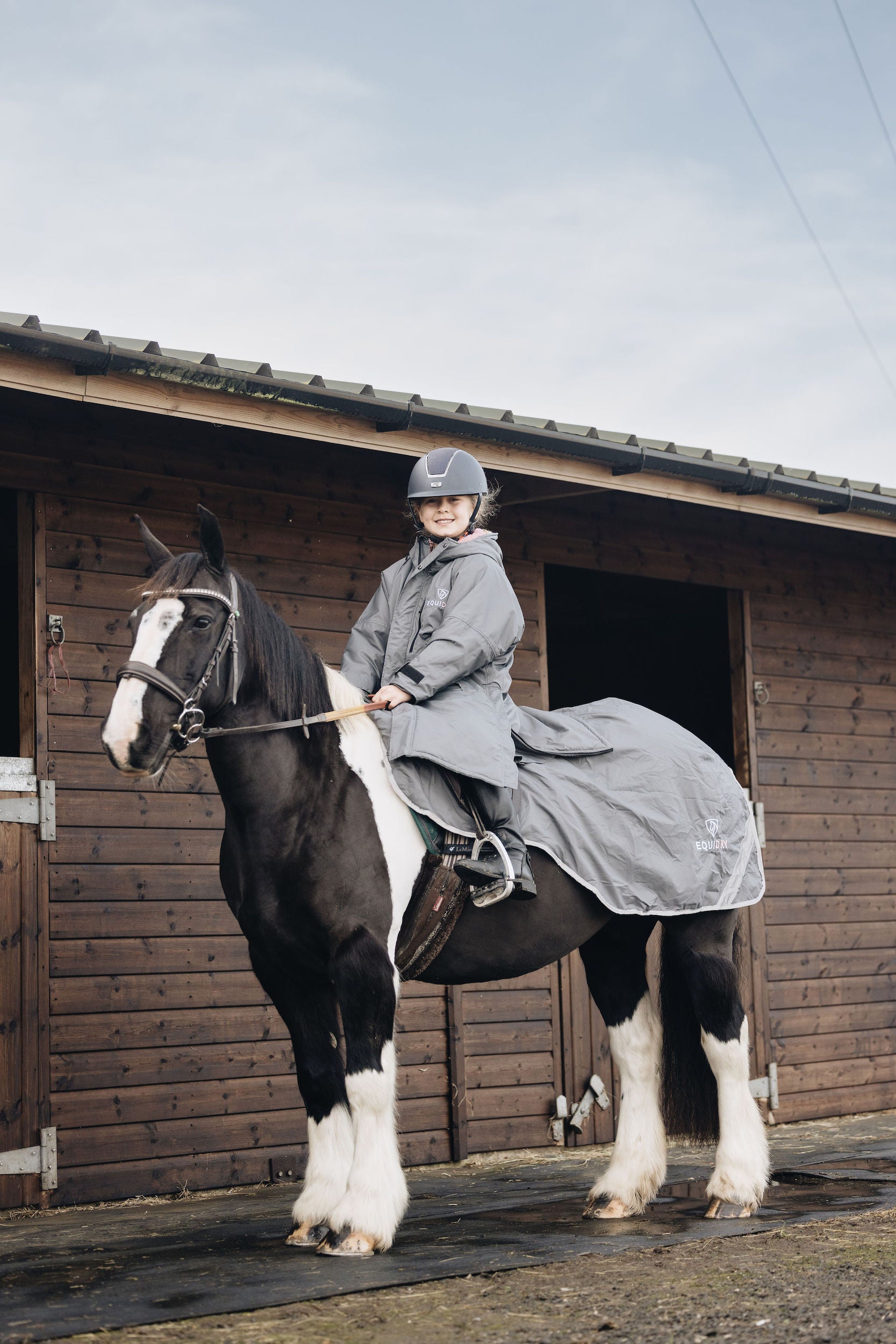 EQUIDRY women's long waterproof horse riding coat in charcoal/pale pink girl on horse with matching exercise sheet