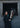EQUIDRY women's long waterproof horse riding coat in black/turquoise modelled by rider on yard with horse 