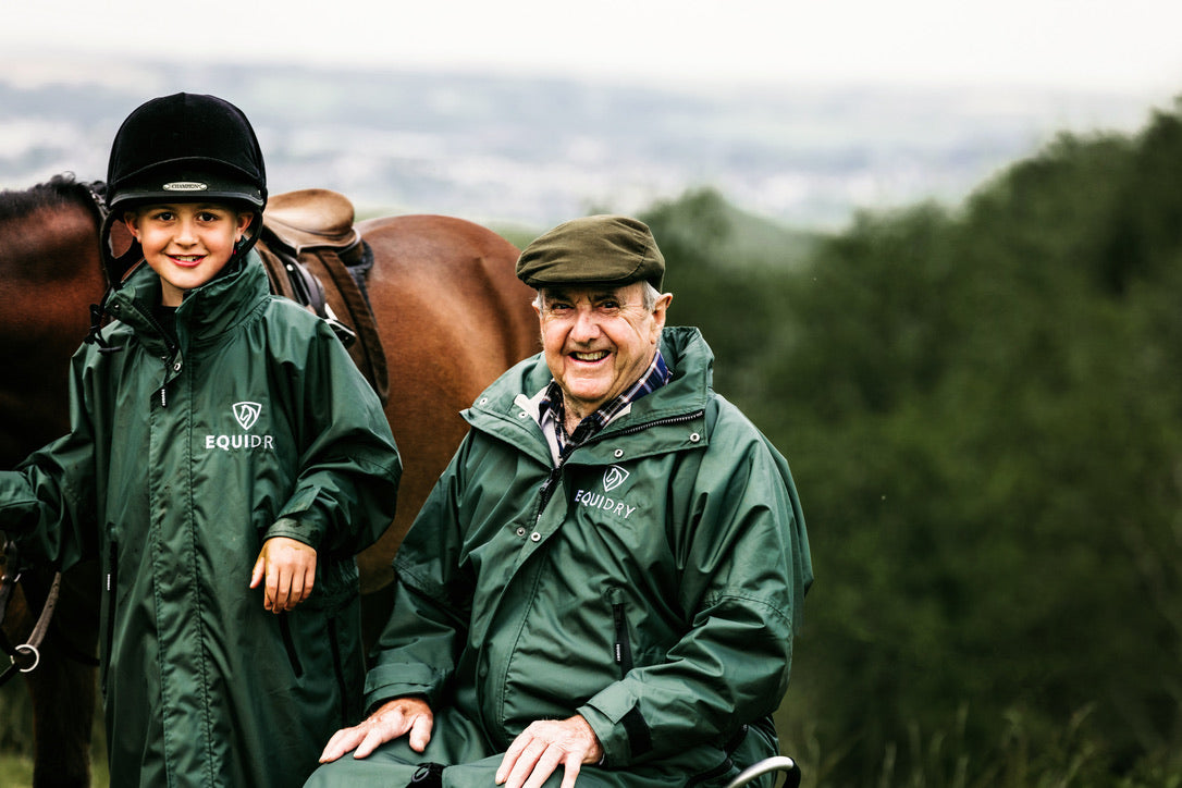 Black Forest Green EQUIDRY Equimac long waterproof raincoat worn by young horse rider and older man