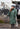 EQUIDRY women's thin fleece stowaway hood long waterproof horse riding coat in black forest green stood with horse