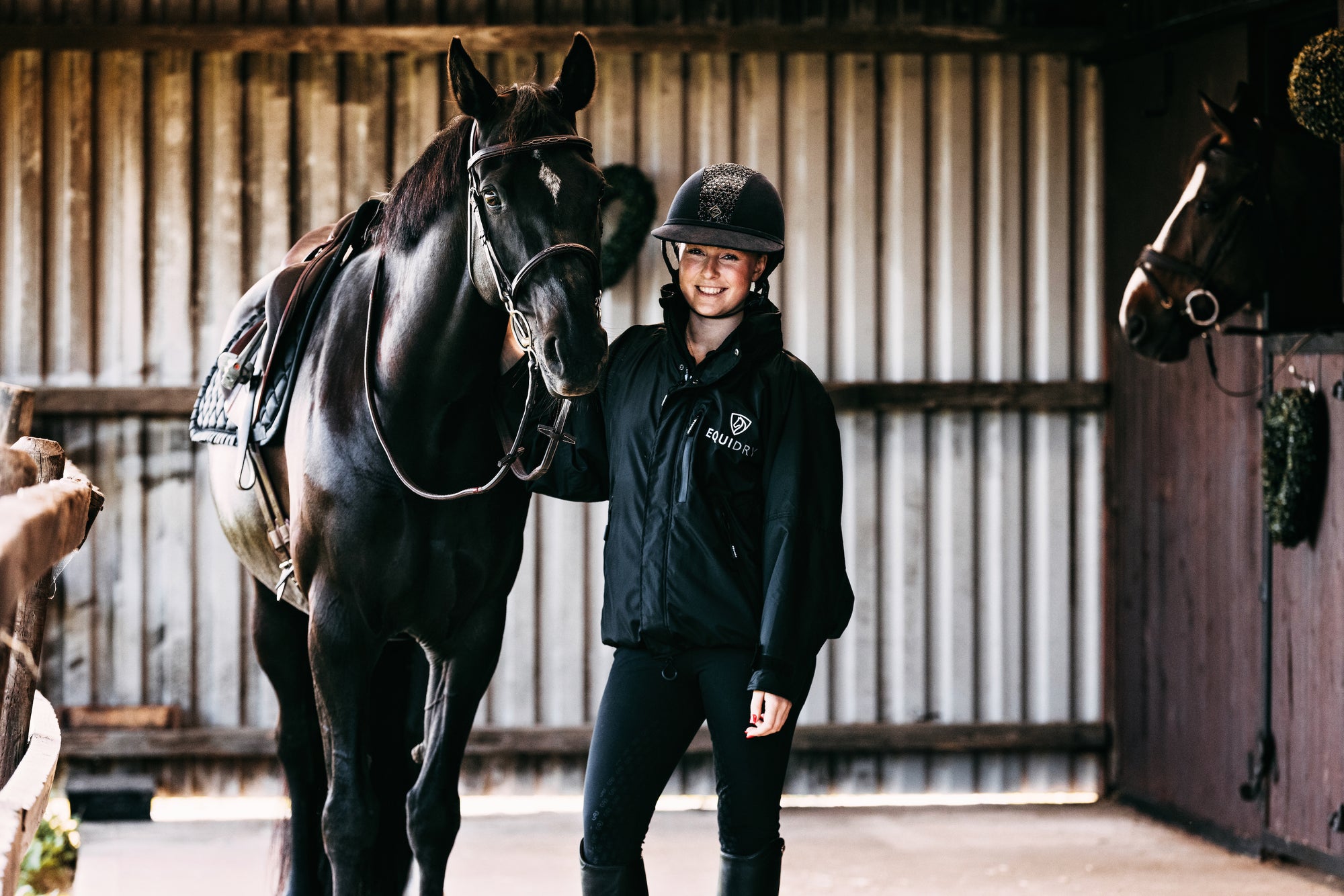 EQUIDRY women's waterproof short blouson style horse riding jacket in black/black with horse on yard