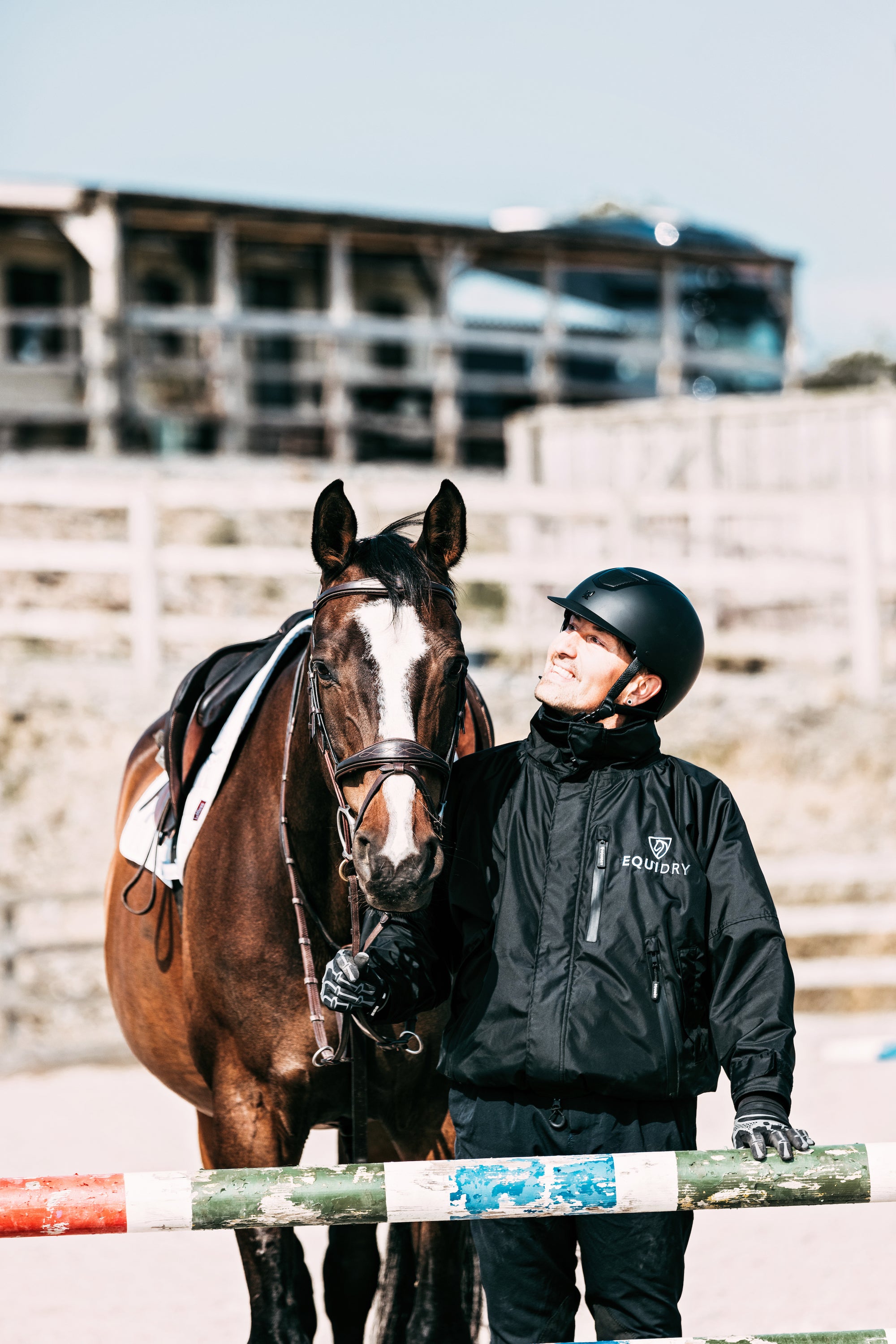 EQUIDRY men's waterproof short blouson style horse riding jacket in black with horse in arena 