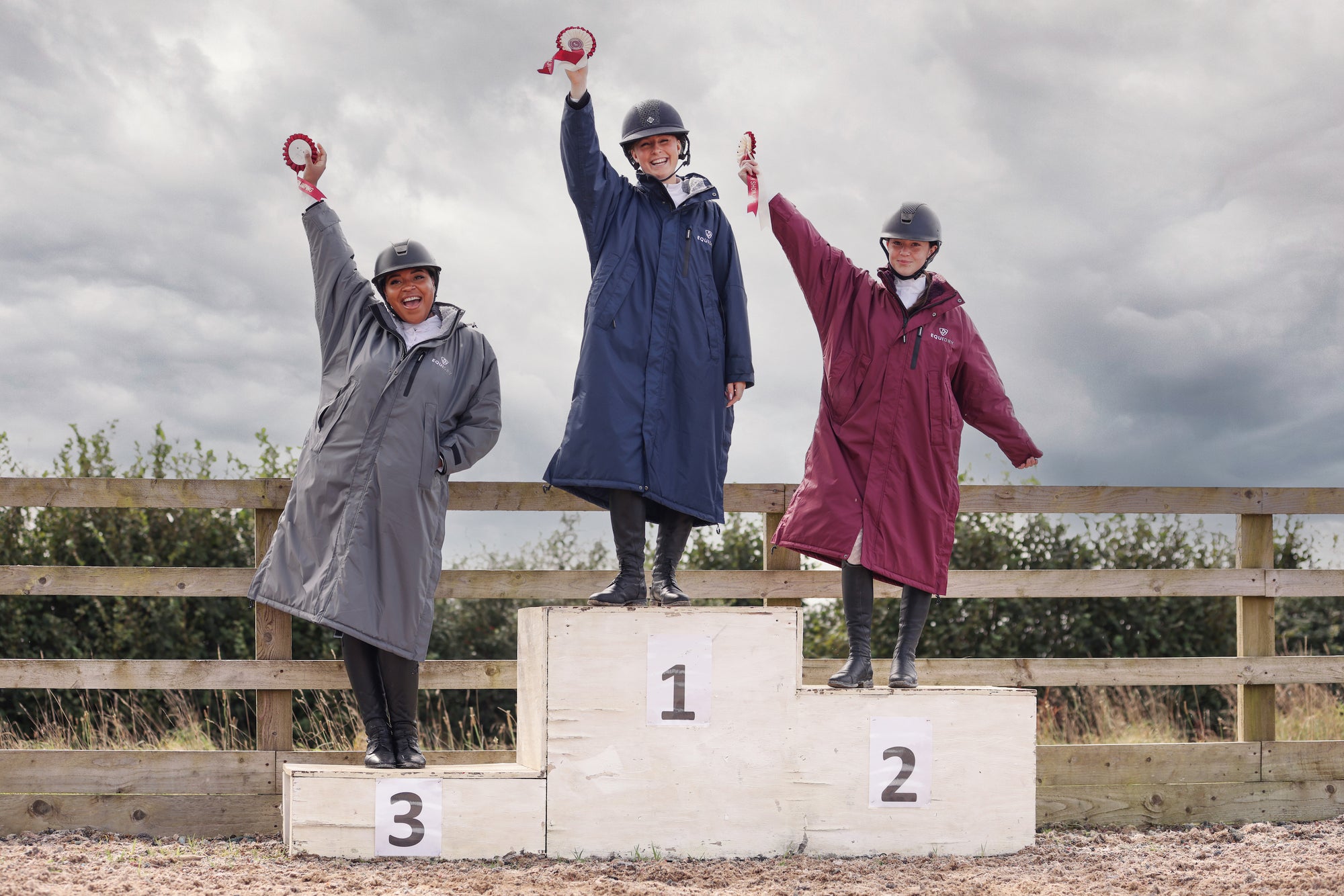 Evolution Pro women's Warm Waterproof Horse Riding Coat Thick Fleece Lining Stowaway Hood in Plum 3 riders on podium after show 